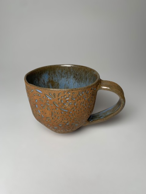 Taza mediana pasta café expuesta con esgrafiado celeste brillante. Interior blanco/celeste